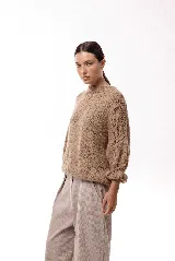 Sweater de tejido de punto con silueta relajada, cuello redondo y mangas 3/4 abullonadas con puños ajustados que aportan volumen.