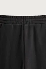 Pantalón de corte relajado confeccionado en tejido de algodón, con cintura elástica y detalle de pliegues estructurales en las perneras. Cuenta con bolsillos frontales y un bolsillo trasero de plastrón.