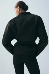 Cazadora corta de Zara color rojo, con cuello smoking, manga larga y cinturón ajustable del mismo tejido.