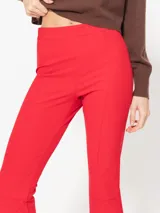 Pantalón marrón de punto liso, con cintura elastizada y bota amplia con tajo en el delantero.