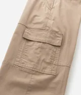 Pantalón de corte baggy relaxed confeccionado en sarga de algodón. Presenta cintura con trabillas, cierre tradicional con botón y cremallera, bolsillos laterales y bolsillos cargo en los muslos.