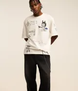 Pantalón de jean corte super baggy con efecto jaspeado o mármol, cintura con trabillas, cierre tradicional y bolsillo cargo lateral con cadena decorativa.