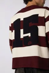 Remera de tejido de punto con diseño de rayas horizontales anchas en color bordó y crema, de corte oversize y cuello redondo.