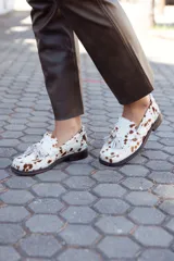 Mocasines de cuero con estampado animal print de vaca, hechos a mano en Uruguay.