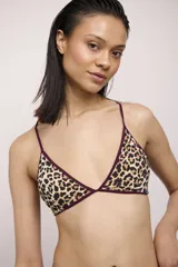 Top de bikini con diseño triangular y estampado animal print de leopardo, con ribetes en tono bordó y tirantes finos.