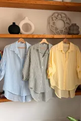Camisa de algodón con diseño de rayas verticales en tonos amarillo y blanco, de corte clásico y manga larga.