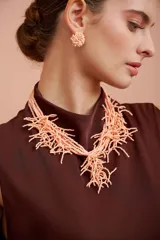 Collar color salmón oscuro, confeccionado a base de pequeños abalorios y cuentas formando flecos colgantes entrelazados.