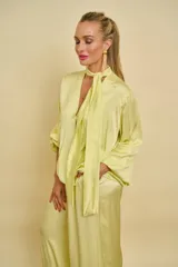 Blusa de satén color amarillo claro con escote en V y cuello de lazo ajustable. Presenta mangas largas holgadas con puños elásticos y diseño fluido.