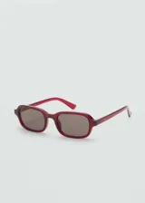 Gafas de sol con diseño rectangular y montura de pasta en color rojo traslúcido. Cuentan con protección UV categoría 3.