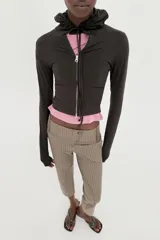 Sudadera cropped de punto con cierre frontal de cremallera metálica, capucha ajustable con cordones y mangas largas con puños en rib.