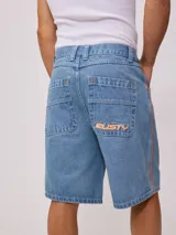 Bermuda de jean de mezclilla negra con efecto lavado, corte recto y costuras en contraste de hilo blanco. Presenta un parche bordado con el logo "Rusty" en color celeste en el bolsillo trasero derecho.