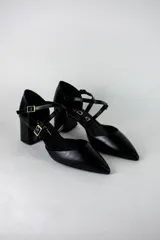 Sandalia de vestir color negro con punta fina cerrada, taco cuadrado medio y tiras cruzadas con hebillas ajustables.