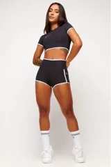 Short deportivo de tiro alto, color negro, con ribetes blancos en los bordes y bolsillos laterales.