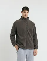 Campera de micropolar color verde oscuro, con cuello alto, cierre frontal completo, bolsillos laterales y un bolsillo con cierre en el pecho.