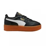 Championes urbanos Puma modelo Palermo Platform, color negro con franja lateral blanca y suela de plataforma color caramelo. Presenta detalles en dorado en la lengüeta y el lateral.