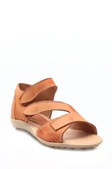 Sandalia de cuero beige con diseño de múltiples tiras con cierre de velcro. Presenta una combinación de texturas, incluyendo cuero con relieve tipo croco en el talón y la puntera, y cuero liso en las tiras superiores. Cuenta con una suela plana de goma con relieve antideslizante.