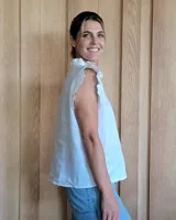 Musculosa celeste de denim con cuello mao con volados y cierre frontal con botones.