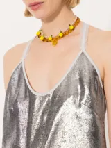 Top corto dorado con breteles finos y espalda cruzada con flecos.