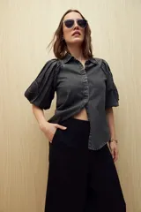 Pantalón de lino color negro, de tiro alto y corte wide leg con pierna ancha y caída fluida.