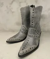 Bota de caña media color gris con punta combinada con tachas de metal y cierre lateral.