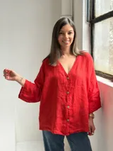 Camisa oversize de lino color rojo, con escote en V, mangas largas amplias y cierre frontal con botones.