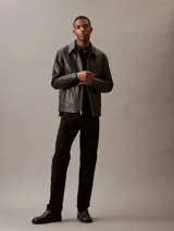 Camisa negra de lino y algodón, de corte clásico, con cuello en punta, cierre frontal con botones y mangas largas con puños abotonados.