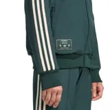 Campera deportiva Adidas Terrace Icons de la Juventus, color verde oscuro con detalles en blanco. Presenta cierre frontal completo, cuello alto, bolsillos laterales con cierre y logo de Adidas bordado en el pecho.