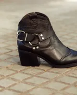 Texana de caña baja confeccionada en cuero natural, con taco cuadrado y detalle de estribo metálico lateral. Diseño versátil con cierre lateral.