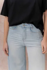 Pantalón jean tiro alto de color celeste claro, con corte wide leg y largo cropped. Presenta bolsillos funcionales y terminación de ruedo ancho.