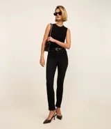 Pantalón de jeans negro, corte slim, con cintura media, trabillas en la cintura, bolsillos delanteros y traseros, y abertura en el ruedo.