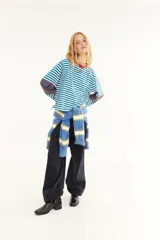 Remera de manga larga con corte boxy, confeccionada en algodón. Presenta un diseño de rayas horizontales en tonos azul y fucsia, con detalles de rayas verticales en los codos, tajos laterales y logo bordado en el pecho.