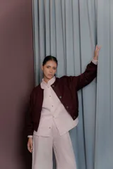 Chaqueta de paño color bordó con cuello mao y cierre frontal de botones. Presenta un diseño estructurado con puños con tajo y forro interior de seda estampado.