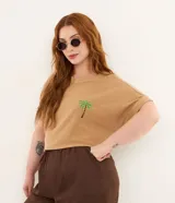 Remera color tostado de algodón texturizado, con cuello redondo, mangas cortas con vuelta y un delicado bordado de palmera en el pecho.