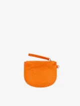 Monedero pequeño semicular de cuero vacuno texturizado color naranja, con cierre superior, tirador de correa de cuero y argolla lateral. Cuenta con el logotipo de la marca grabado en el frente.
