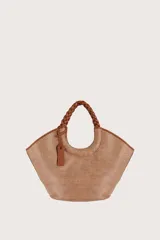 Bolso tipo shopper de textura tejida en color natural, con asas superiores trenzadas en tono marrón y detalles de ribetes en cuero sintético. Incluye un colgante decorativo de cuero con logo grabado.