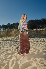 Falda midi de cuero marrón con detalle de crochet artesanal en el ruedo.