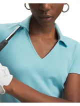 Remera tipo polo de manga corta, color celeste, con cuello en V abierto y diseño ligeramente corto. Confeccionada en tejido elástico y transpirable con tecnología de absorción de sudor.