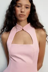 Vestido mini negro sin mangas, con cuello mao, abertura frontal tipo lágrima y forro interior a tono. Cierre en la espalda con cremallera oculta.