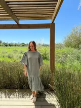 Vestido verde oliva de lino, corte suelto, con mangas abullonadas y volado en el ruedo.