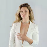 Collar plateado con dije circular calado de diseño abstracto.