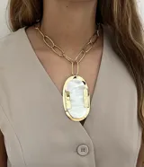 Collar de cadena de eslabones grandes en bronce con un dije central ovalado de gran tamaño, compuesto por una base de bronce y una incrustación de nácar.