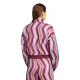 Campera deportiva Adidas de la colección Farm, con diseño de estampado geométrico en tonos bordó, violeta y amarillo. Presenta cuello alto, cierre frontal completo, mangas largas con las icónicas tres tiras en color turquesa y puños acanalados.