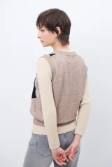 Chaleco de punto con diseño de rombos en tonos beige, marrón y gris. Presenta cuello redondo y corte ajustado a la cintura.