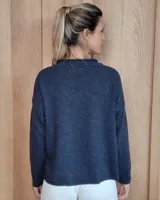 Sweater de tejido de punto color turquesa, con cuello en V y mangas largas de corte holgado.