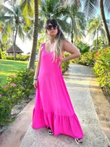 Vestido largo fucsia con breteles finos y detalle de tachas doradas en los breteles.