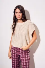 Chaleco de punto con textura acanalada y acabado brillante, de corte holgado, cuello redondo y mangas cortas estilo sisa.