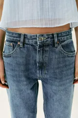 Jeans de tiro alto con diseño de cinco bolsillos, corte slim y bajo con acabado sin costuras. Cierre frontal con cremallera y botón.