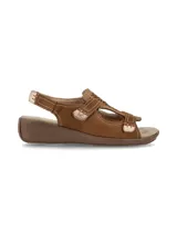 Sandalias Hush Puppies modelo Juliana Tan, de cuero color marrón tostado con detalles de perforaciones láser en el empeine, costuras visibles y cierre con tiras autoadheribles. Cuenta con suela de goma con plataforma baja tipo cuña.