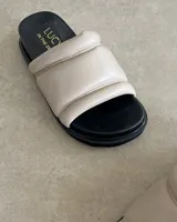 Sandalias bajas color beige, con capellada acolchada de cuero vacuno y plantilla anatómica.