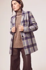 Blazer gris con estampado de cuadros en azul y marrón, solapas de muesca, cierre con un botón y bolsillos con solapa.